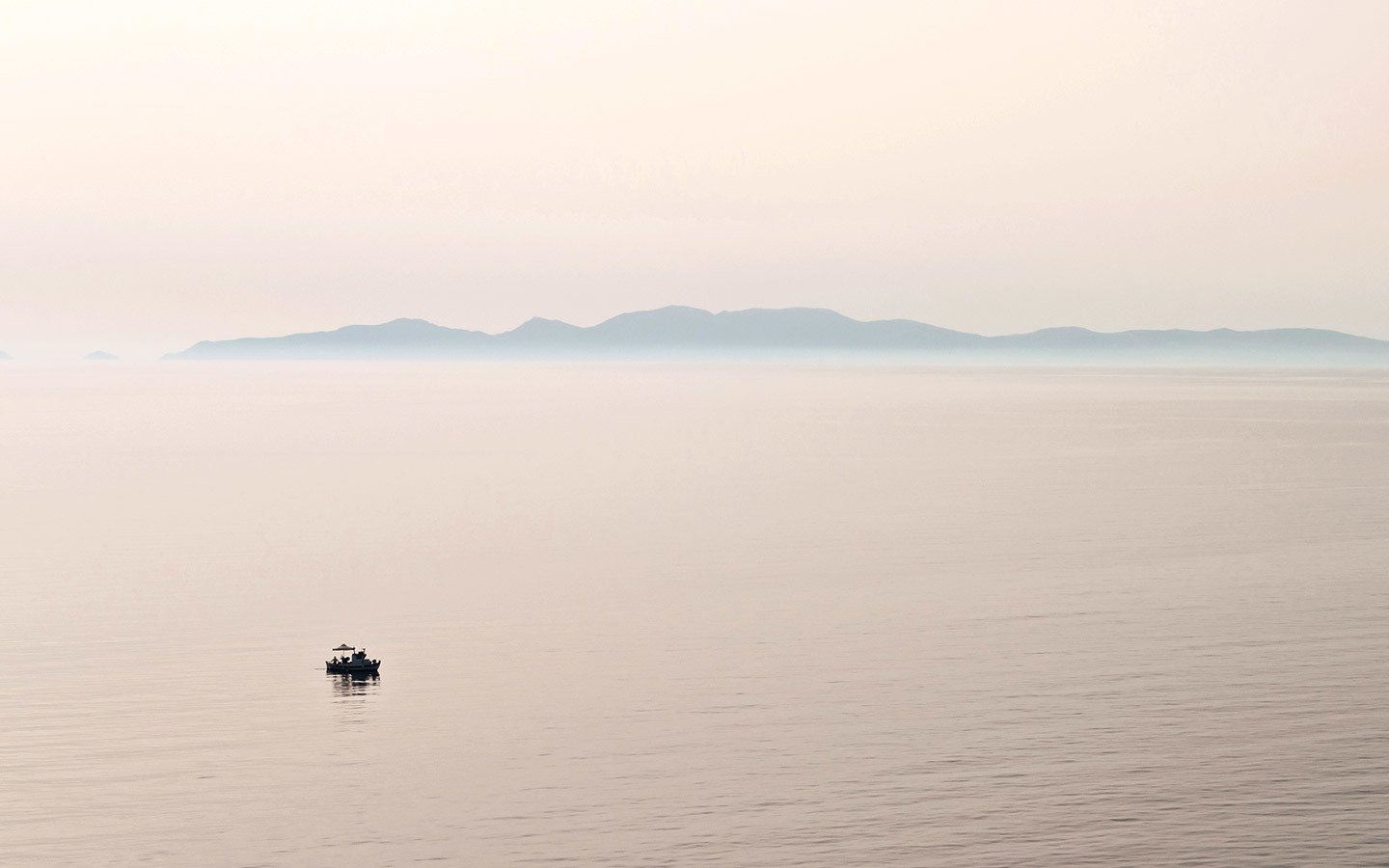 Kleines Boot in der ruhigen See vor Santorin