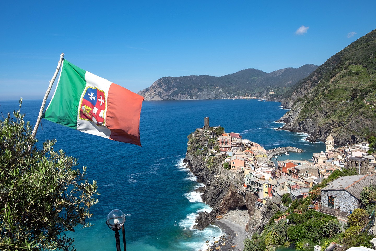 Beautiful Vernazza from the cliff path with a flag blowing in the wind