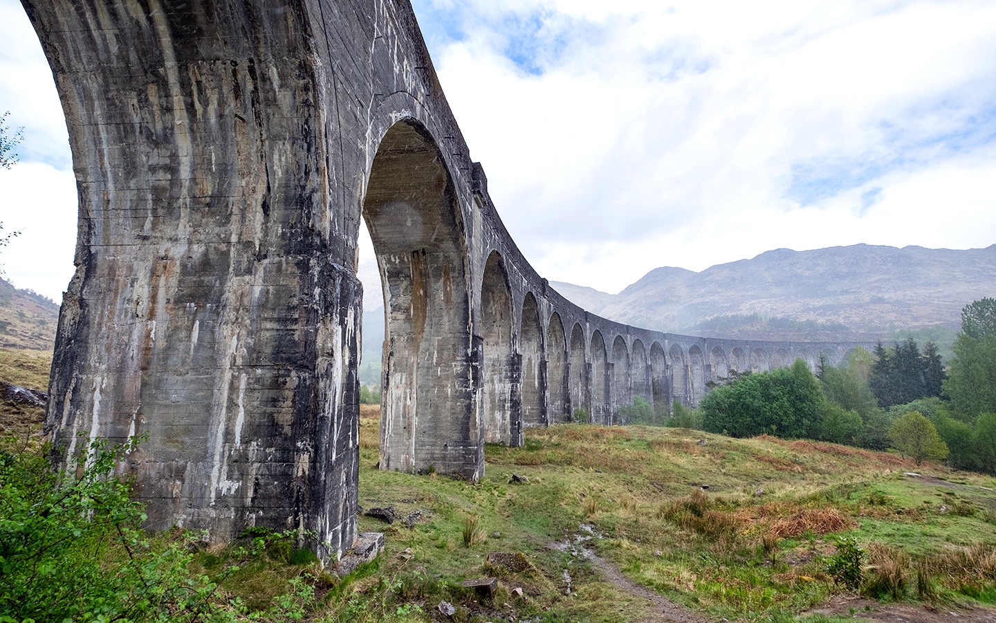 The Jacobite steam train crosses the Glenfinnan Viaduct in Scotland